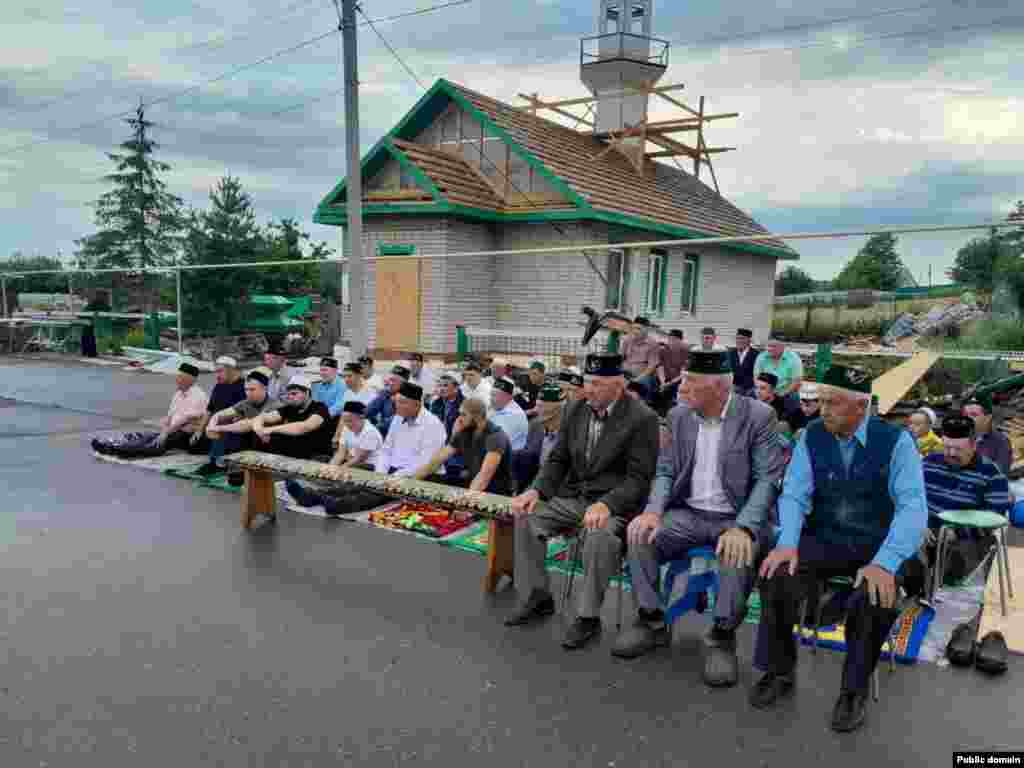 В селе Колмакча Нижнекамского района Татарстана люди молятся на улице, потому что в их мечети (на заднем плане) идёт ремонт