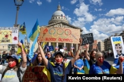 Украинцы на митинге в Париже в память о сотнях украинских спортсменов, погибших в результате российского вторжения. 13 июля 2024 года