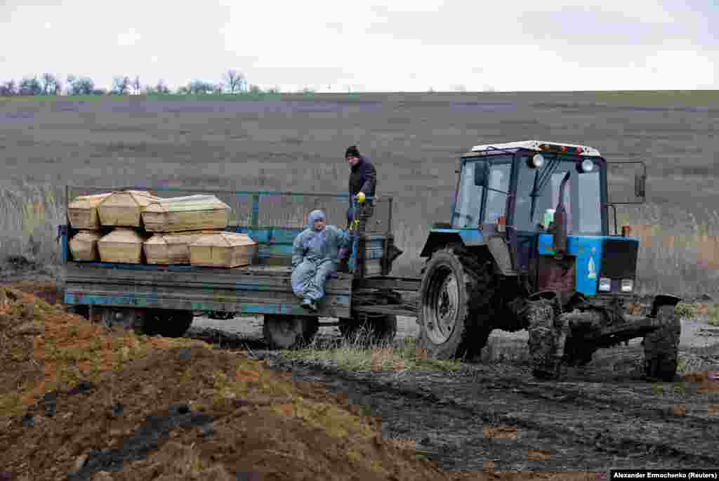 Могильщики везут гробы на кладбище на окраине Мариуполя. Сообщается, что тела мирных жителей обнаруживали в развалинах зданий спустя долгое время после того, как российская осада закончилась. Многие мирные жители укрывались от боевых действий в подвалах многоквартирных домов