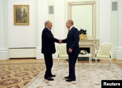 Президент России Владимир Путин обменивается рукопожатием с бывшим президентом Казахстана Нурсултаном Назарбаевым во время встречи в Москве, Россия, 30 июня 2021 года