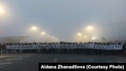 Протестующие на площади с огромной растяжкой «Мы простой народ. Мы — не террористы». Алматы, 6 января 2022 года. Фото Айжаны Жанадиловой