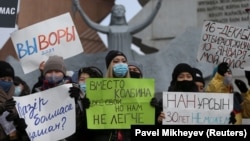 Протестующие держат плакаты во время митинга оппозиции в День независимости. Алматы, 16 декабря 2020 года.