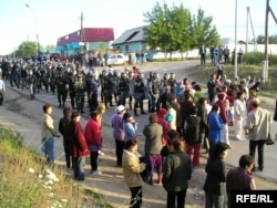 Жители поселка Шанырак под Алматы говорят с вооруженными полицейскими. 14 июля 2006 года.