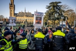 Полицейские разгоняют протестующих во время демонстрации в поддержку палестинцев одновременно со слушанием в Международном суде (МС) дела, инициированного ЮАР, против Израиля. Гаага, 11 января 2024 года