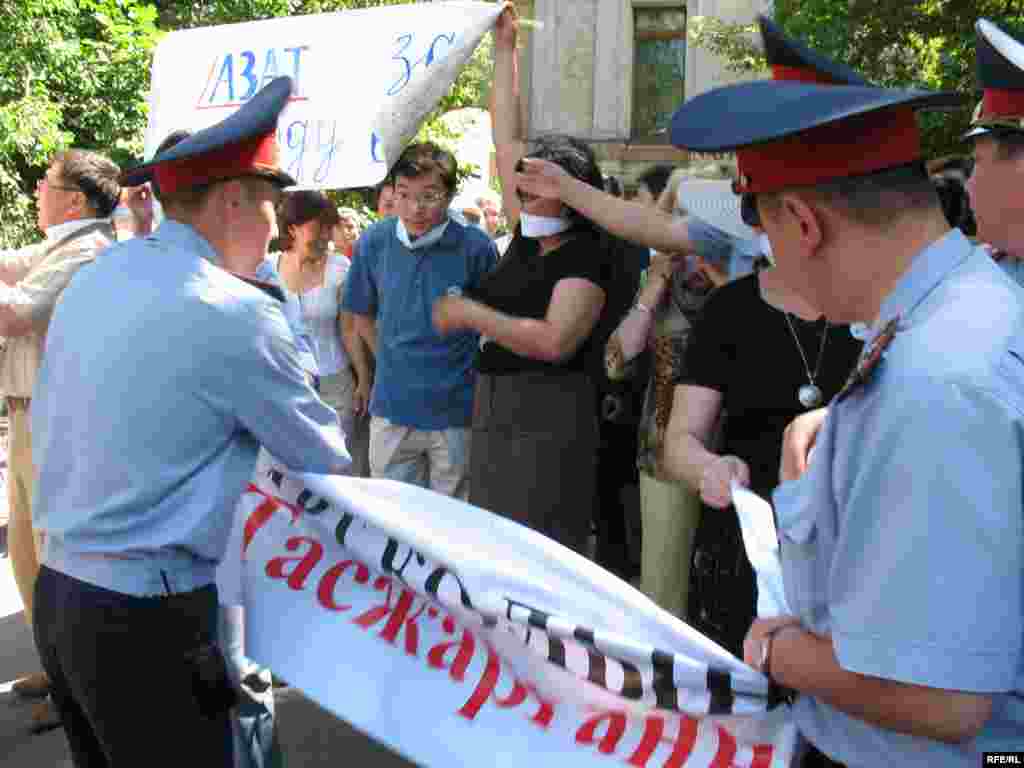 В схватке за плакаты. - Один плакат полицейским удалось отобрать. Алматы, 24 июня 2009 года.