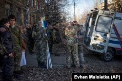 Родственники и члены украинской военно-медицинской части утешают друг друга, оплакивая четырех товарищей, убитых под Дебальцевом в феврале 2015 года.